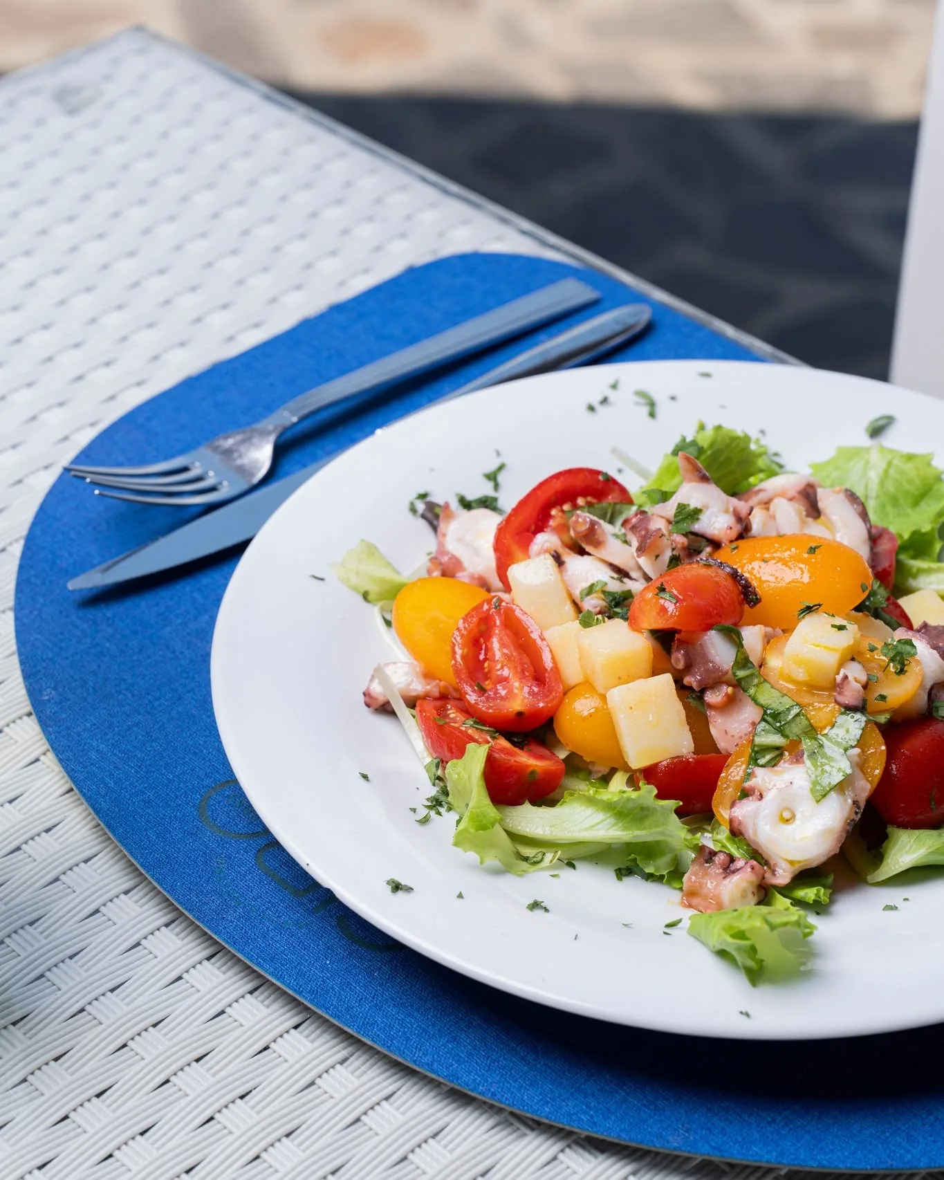 Octopus salad with cherry tomatoes, served in the restaurant