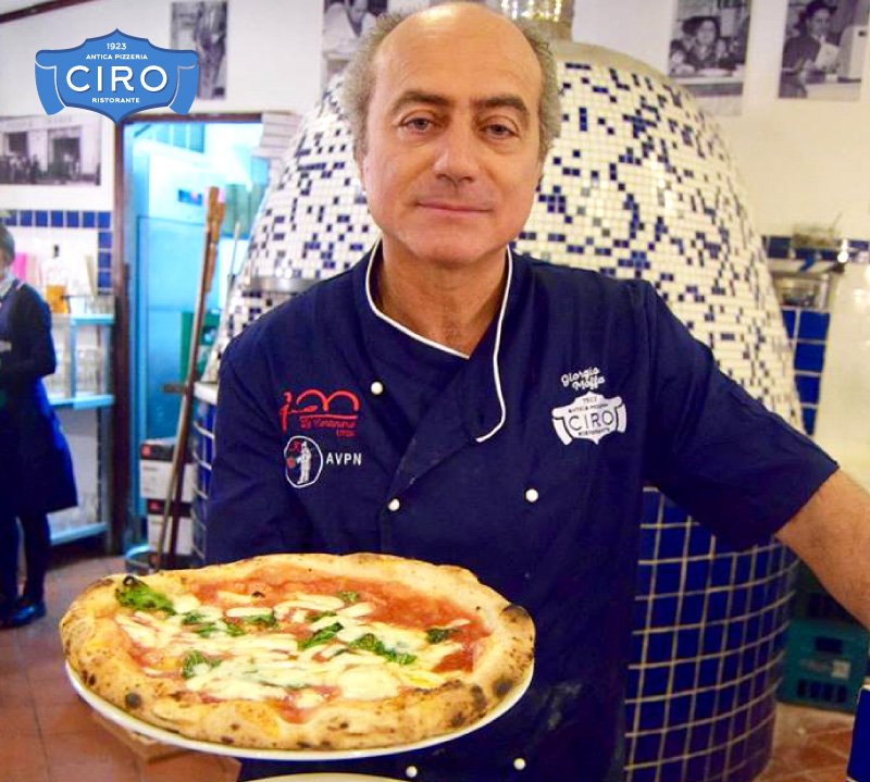 Giorgio Moffa presents a pizza beside the oven at Antica Pizzeria Ciro 1923